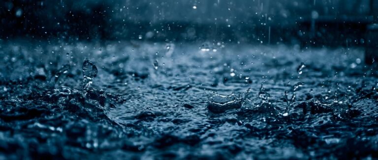 Highly detailed digital render of blue rain drops splashing on a water surface with a dark moody atmosphere aesthetic 4K ultra HD PC desktop wallpaper