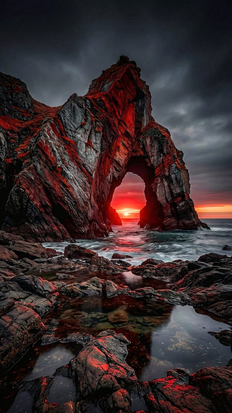 Highly detailed digital render of a majestic natural rock arch on a rugged coastline during a dramatic red sunset with ocean waves aesthetic 4K ultra HD mobile wallpaper