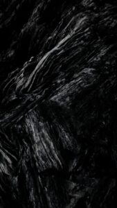 Vertical macro wallpaper of dark obsidian rock texture, jagged stone layers, deep black volcanic glass, high contrast abstract background, sharp details, pitch black aesthetic 4K wallpaper