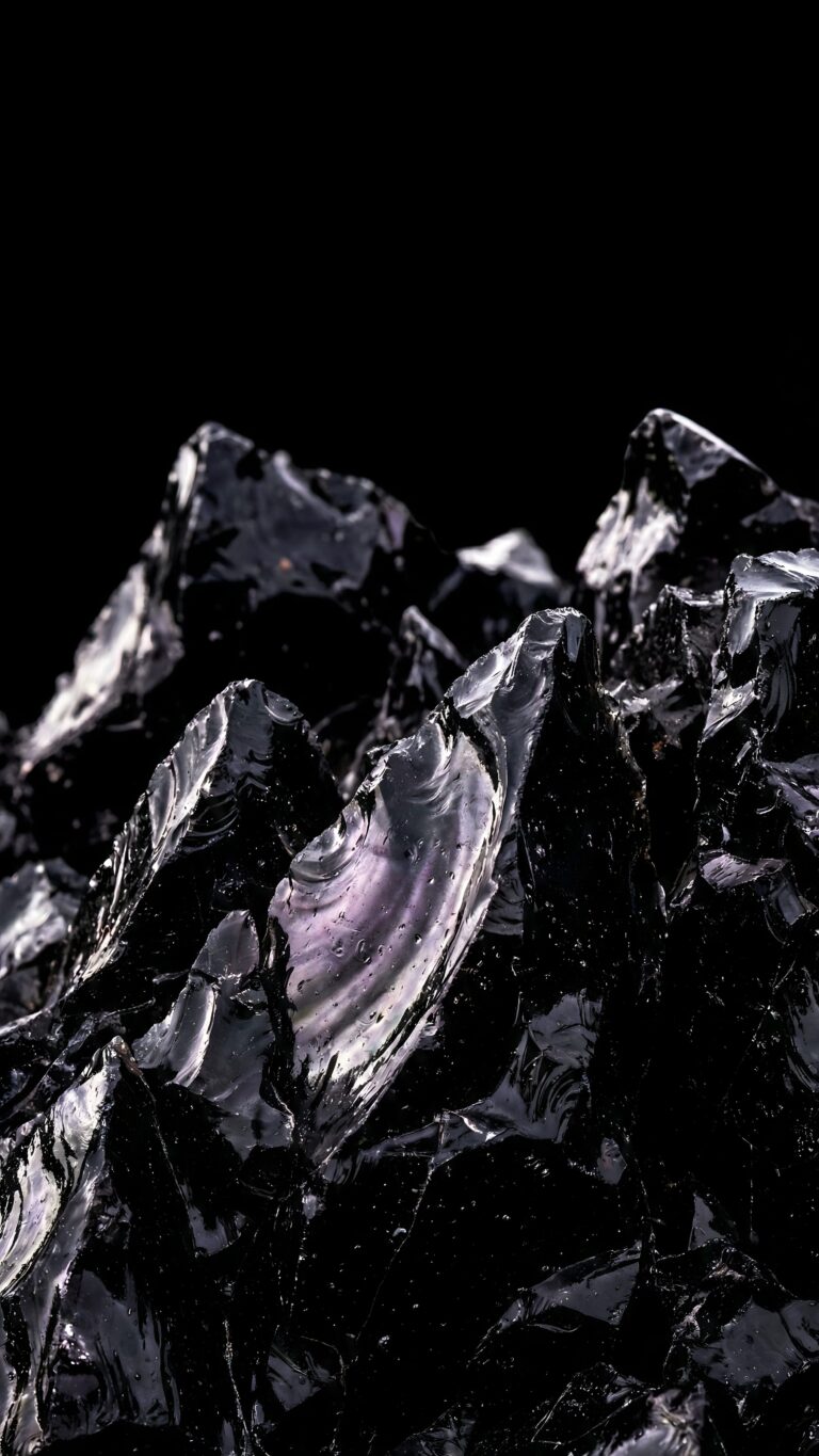 Highly detailed digital render of sharp obsidian black stone crystals with natural reflections against a pure pitch black background aesthetic 4K ultra HD mobile wallpaper