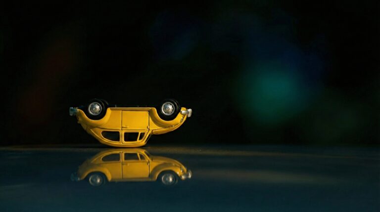 Highly detailed 3D digital render of an upside down yellow classic toy car with a perfect mirror reflection on a dark surface aesthetic 4K ultra HD PC desktop wallpaper
