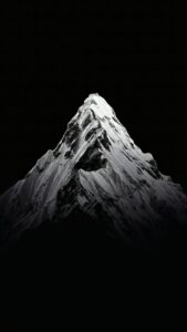 Download free 4K black and white mobile wallpaper of a sharp, snow-covered mountain peak against a solid black background, ideal for AMOLED screens.
