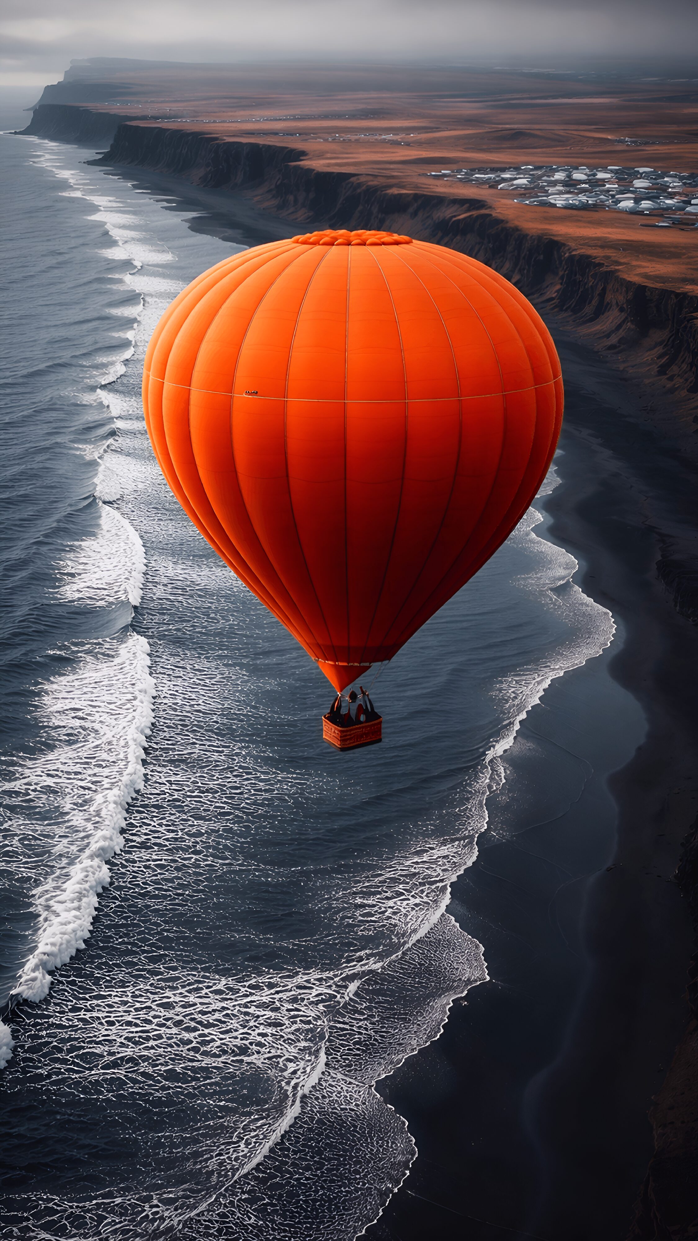 Download free 4K mobile wallpaper of a bright orange hot air balloon flying perfectly over a striking black sand beach and dark ocean waves.