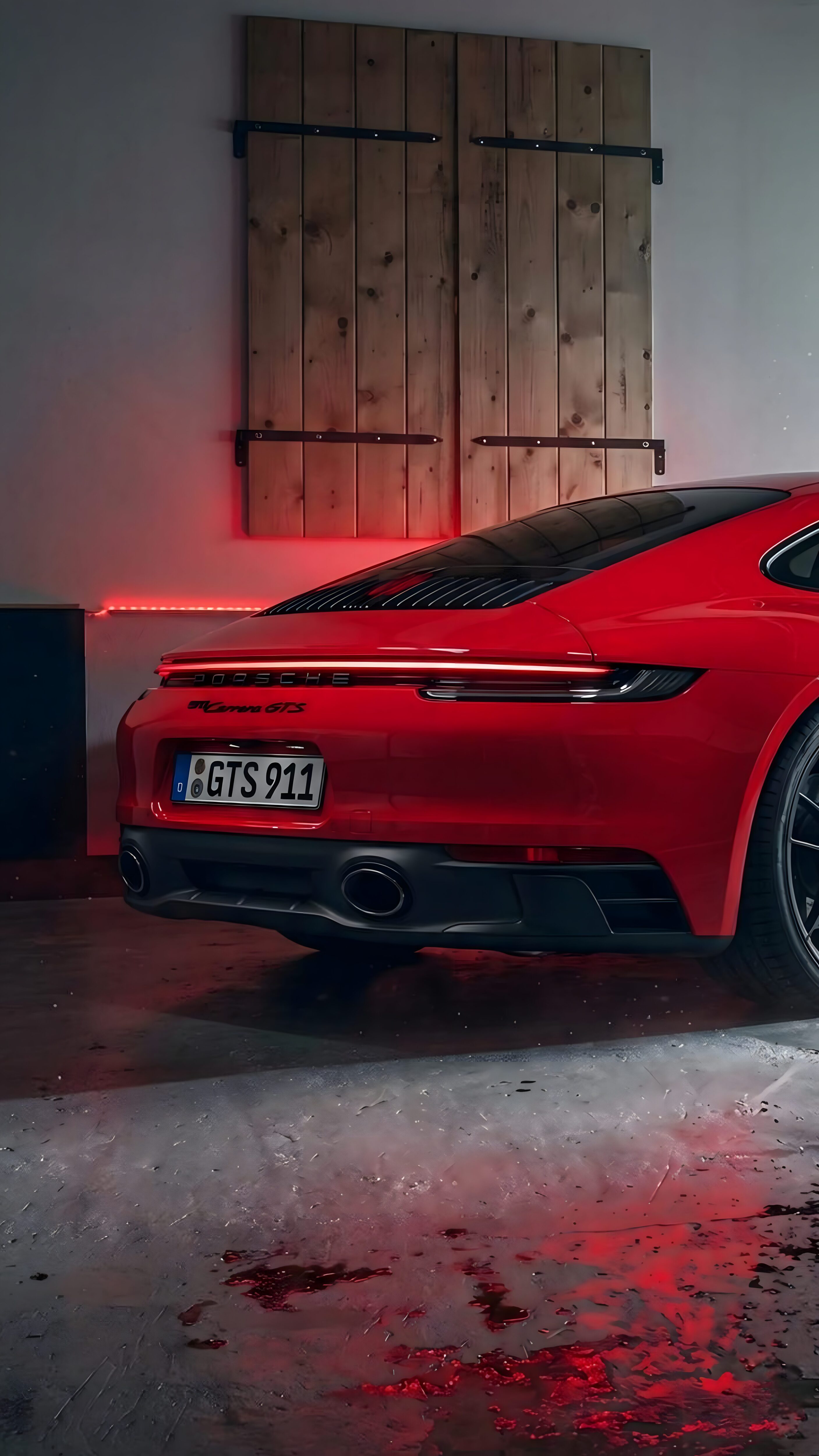 A high-resolution 4K wallpaper featuring the rear of a red Porsche 911 Carrera GTS in a garage with red neon lighting and wooden accents.
