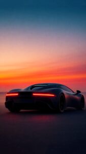 A high-resolution 4K mobile wallpaper of the rear view of a sleek, dark matte supercar with glowing red taillights parked against a vibrant orange and deep blue sunset sky.