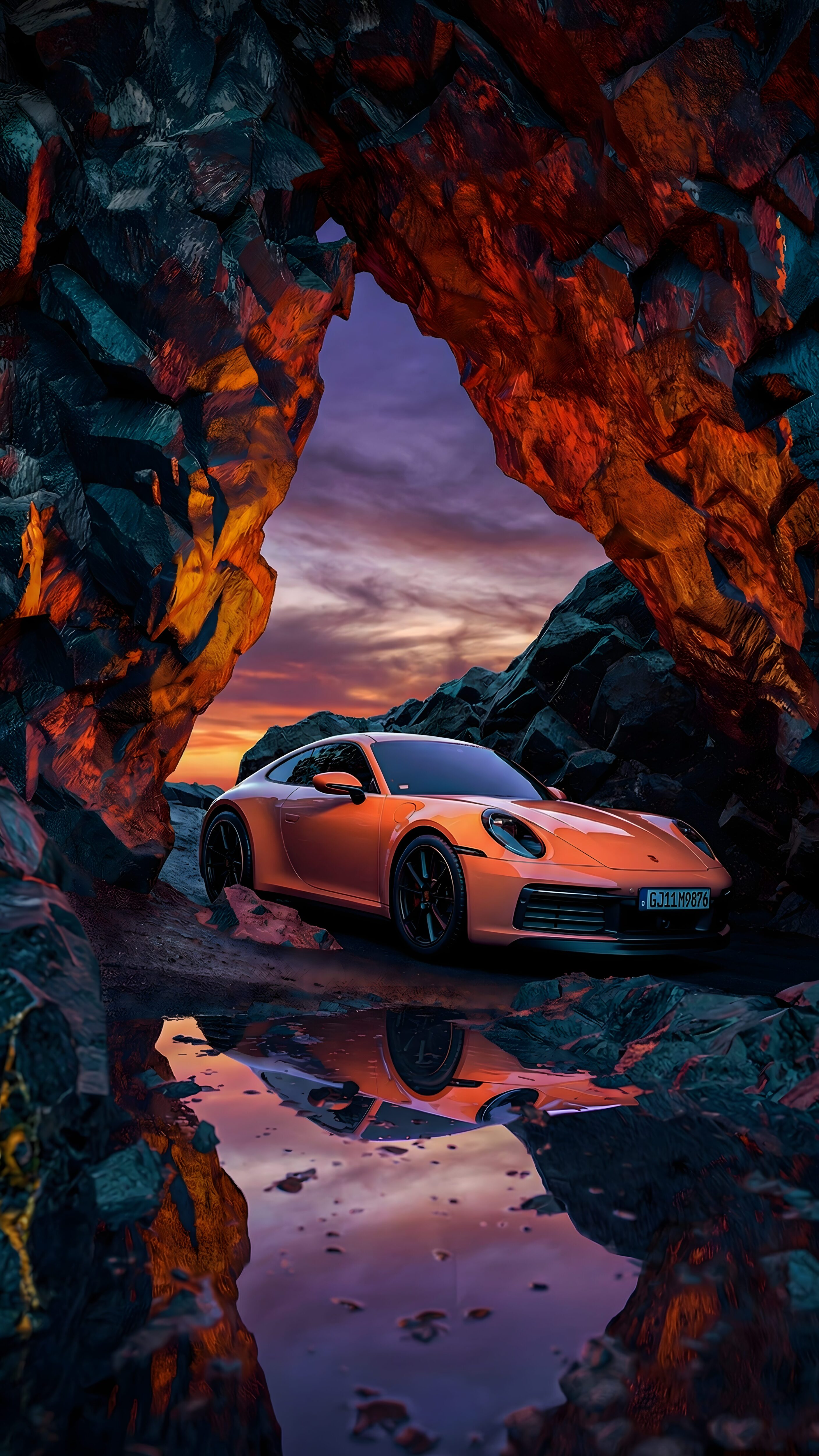 A mobile wallpaper of an orange Porsche 911 parked inside a rocky cave with a puddle reflection at the bottom.
