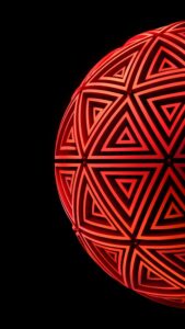 Red geometric 3D abstract sphere with nested triangles on a pitch-black 4K AMOLED mobile wallpaper.
