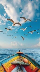 A high-resolution 4K mobile wallpaper of seagulls flying above the prow of a colorful wooden boat on the blue ocean under a cloudy sky.