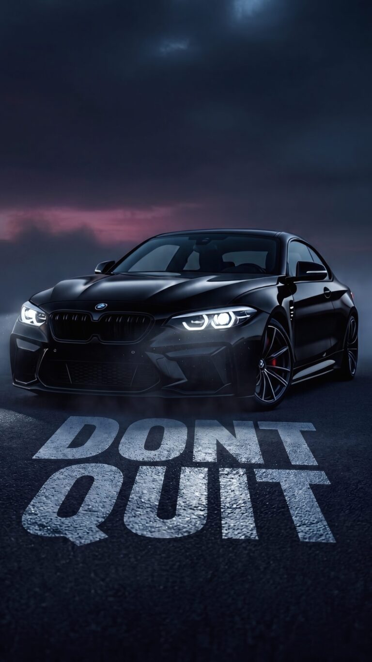 A sleek black BMW sports car parked on asphalt with the motivational phrase DONT QUIT painted on the ground under a dark, moody twilight sky.