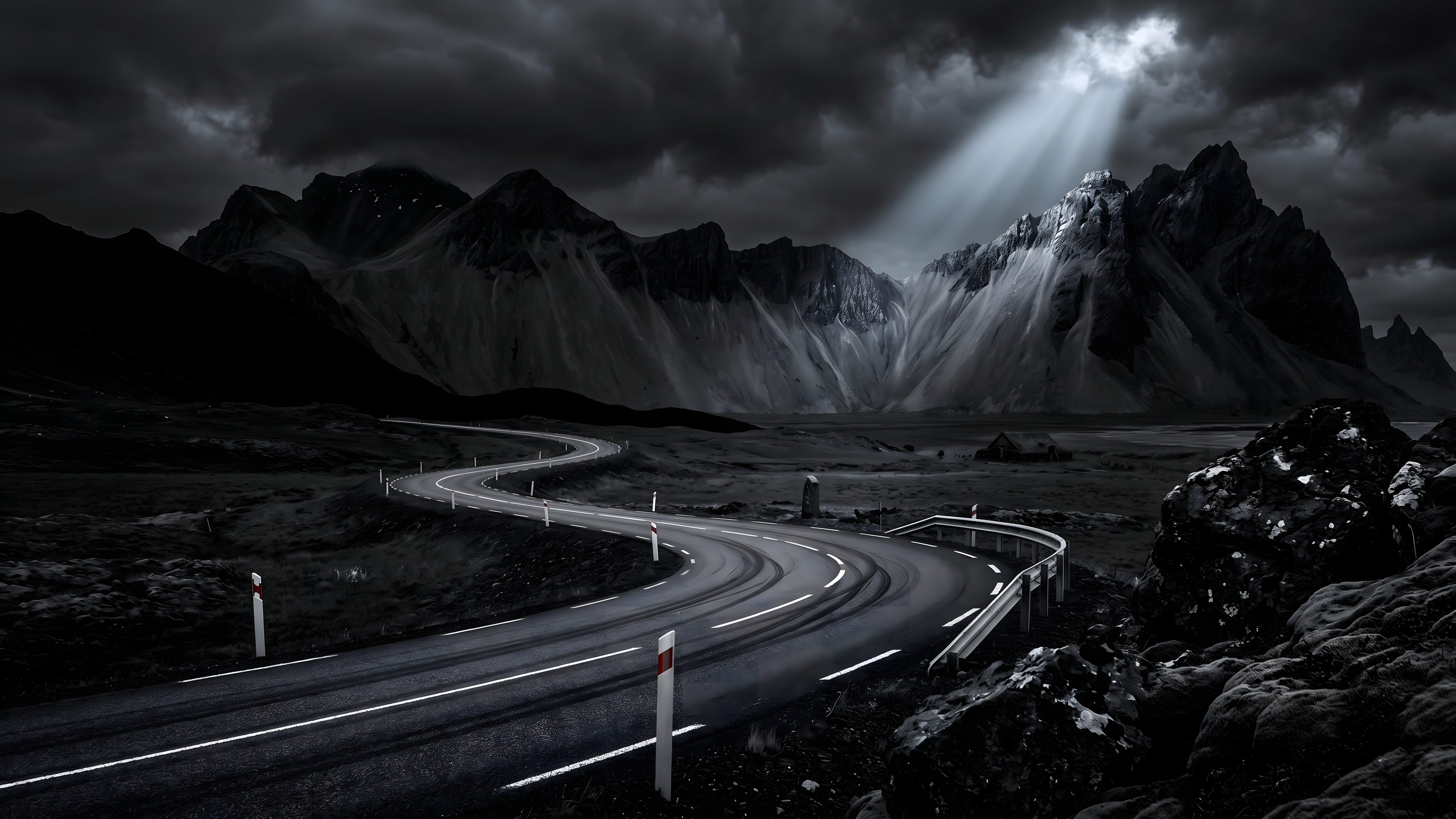 A winding road leading towards sharp, rugged mountain peaks under heavy dark clouds, illuminated by a single bright sunbeam.