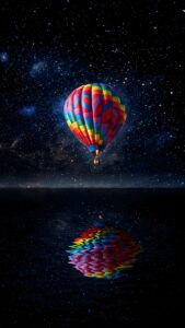 A colorful hot air balloon floating against a dazzling starry galaxy sky, reflecting perfectly on calm dark water.