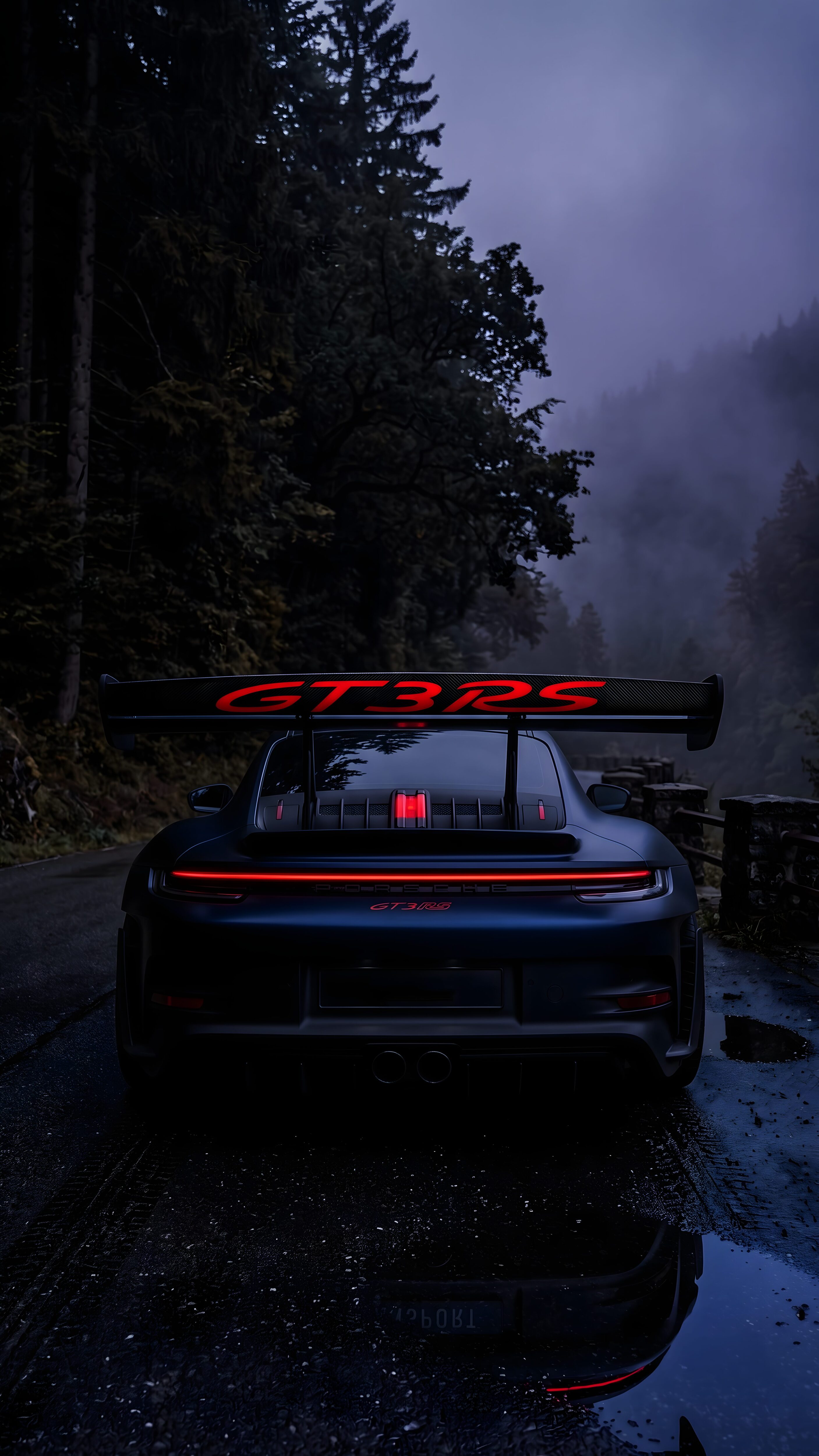 Dark grey Porsche GT3 RS parked on a wet, misty forest road with glowing red taillights, optimized for mobile screens.