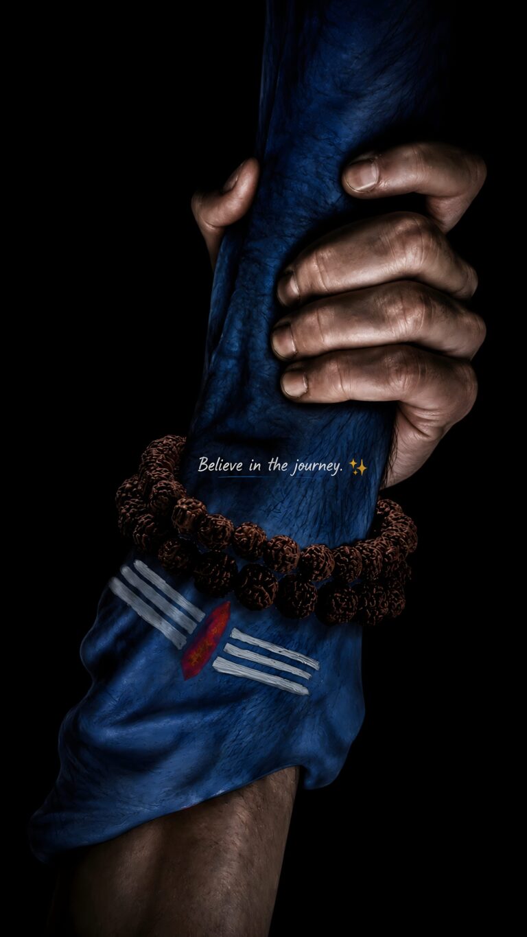 A human hand firmly gripping a blue divine arm adorned with a Rudraksha bracelet and the Tripundra mark of Lord Shiva, featuring the text Believe in the journey.