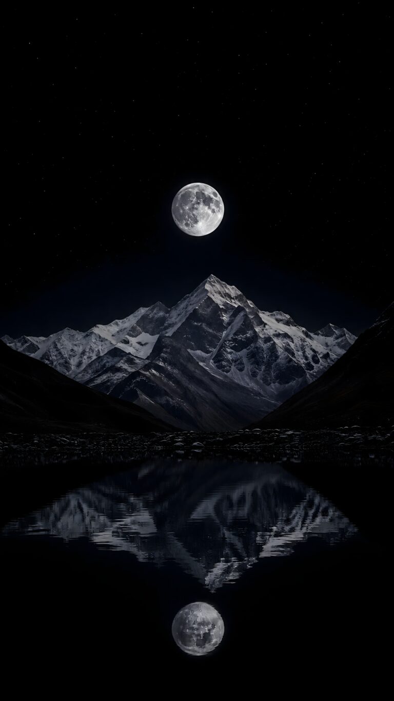 Full moon glowing over a snow-capped mountain ridge with a crisp water reflection against a pure dark night sky.