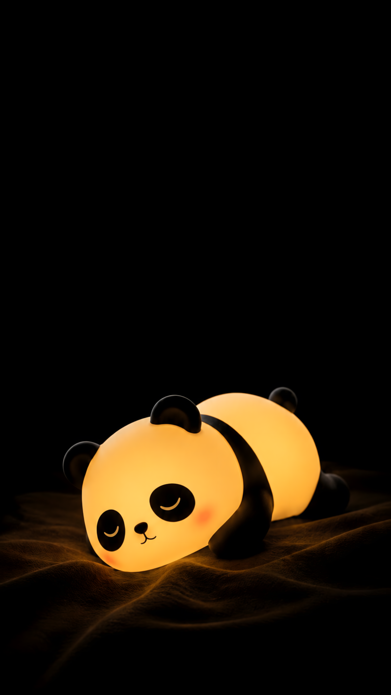 A cute, glowing sleepy panda nightlight resting on a dark fabric surface.