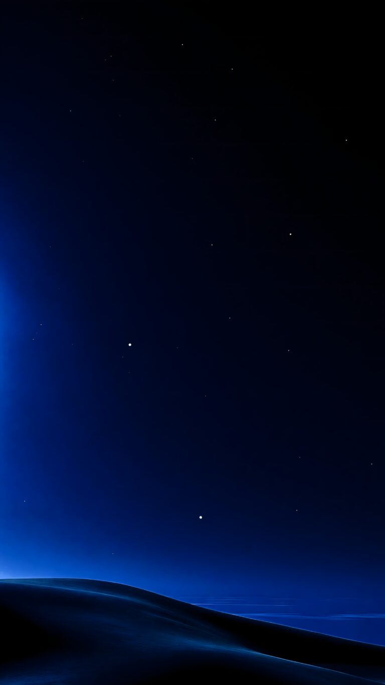 A dark blue night sky featuring scattered bright stars over a smooth, shadowy horizon line.